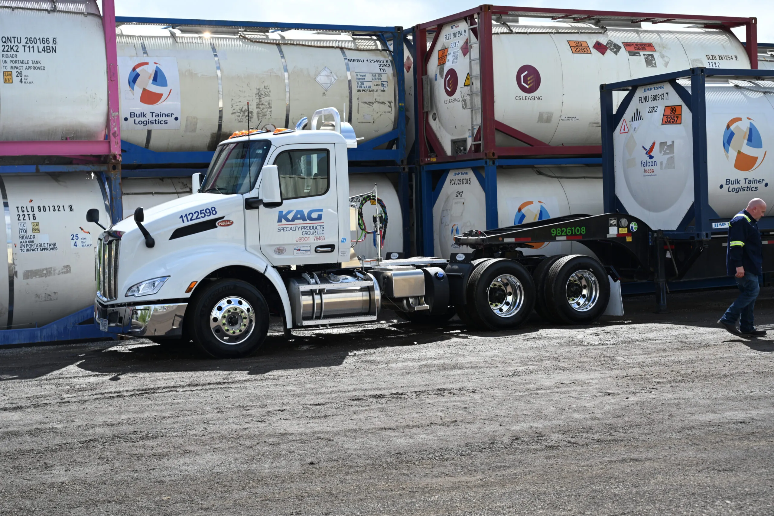 KAG Specialty Products truck maneuvering between ISO bulk containers at a logistics facility