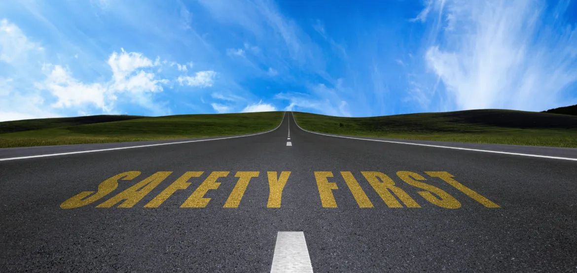 Road stretching into the horizon with Safety First painted in yellow letters on the pavement