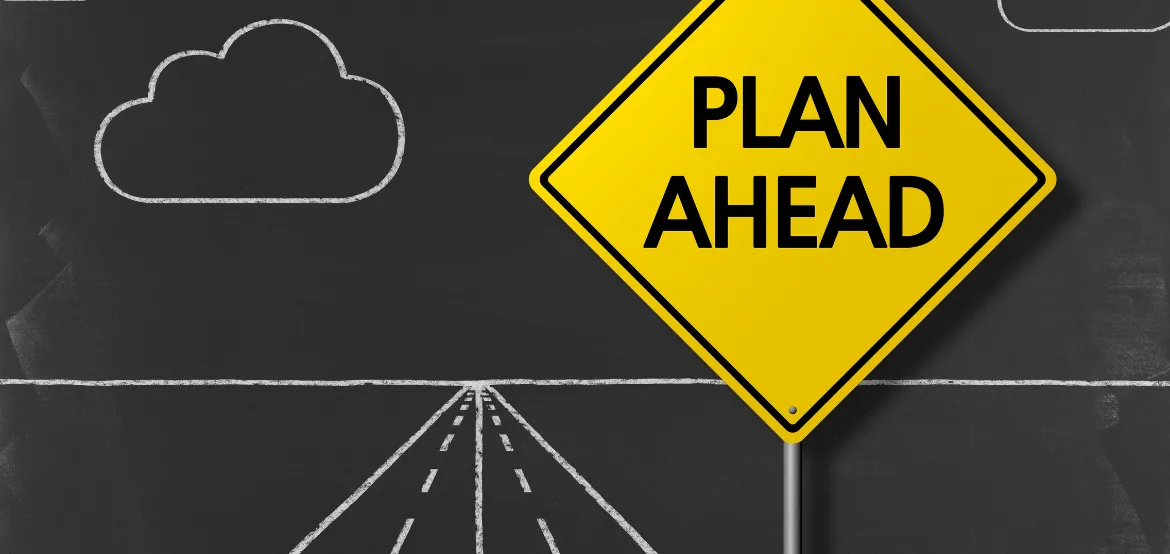 Yellow "Plan Ahead" road sign against a chalkboard with a drawn road and clouds