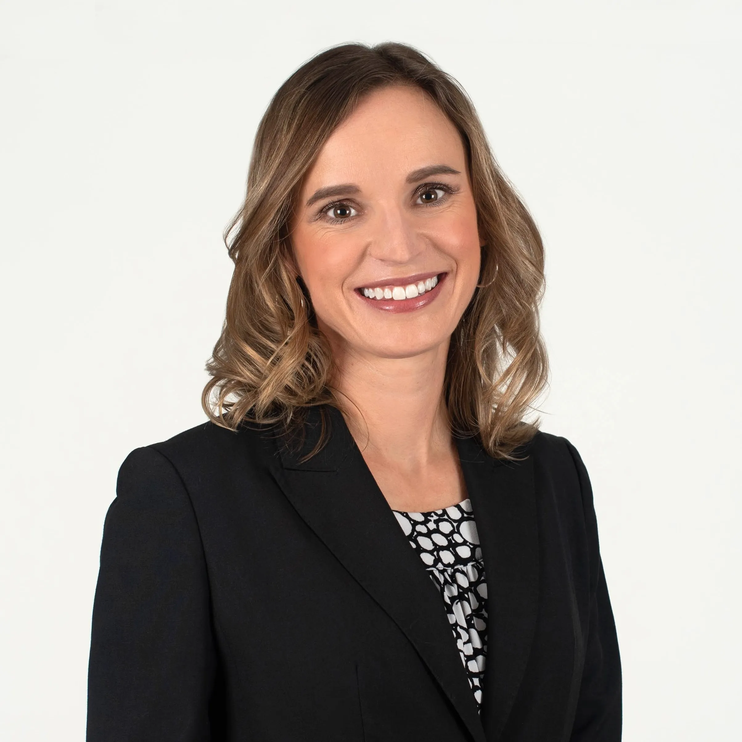 Professional headshot of a smiling woman in a black blazer