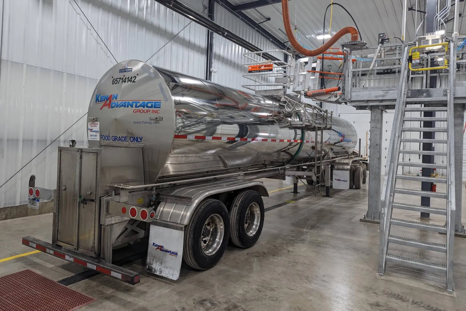 Food-grade tanker trailer inside a KAG tank wash facility undergoing cleaning and sanitation processes to meet food transportation safety standards.